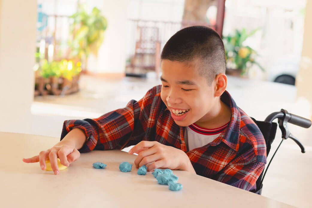 photo of boy in wheelchair playing with toys