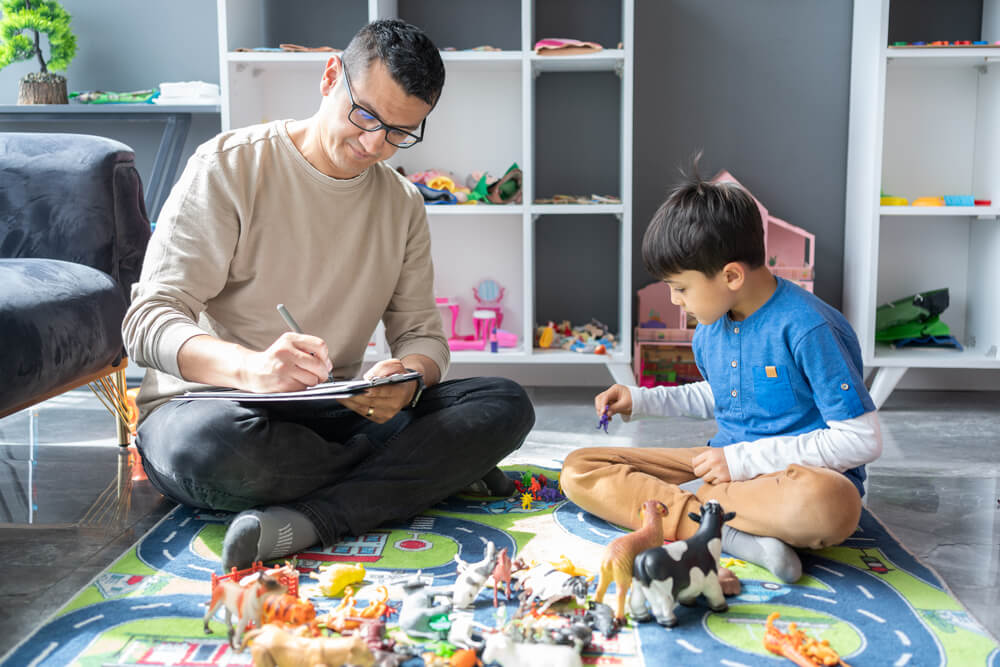 man sitting with and teaching child