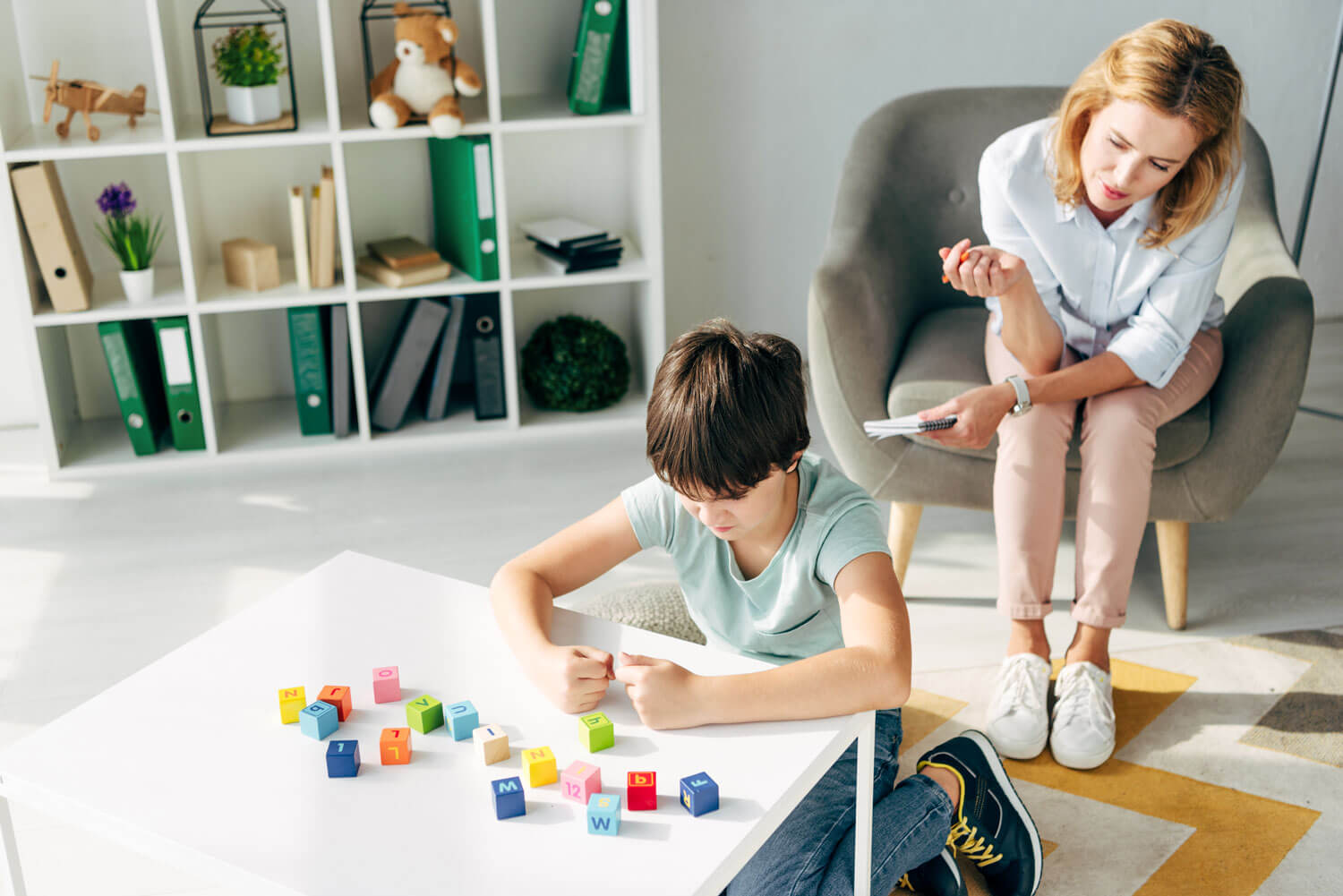 woman sitting and working with child